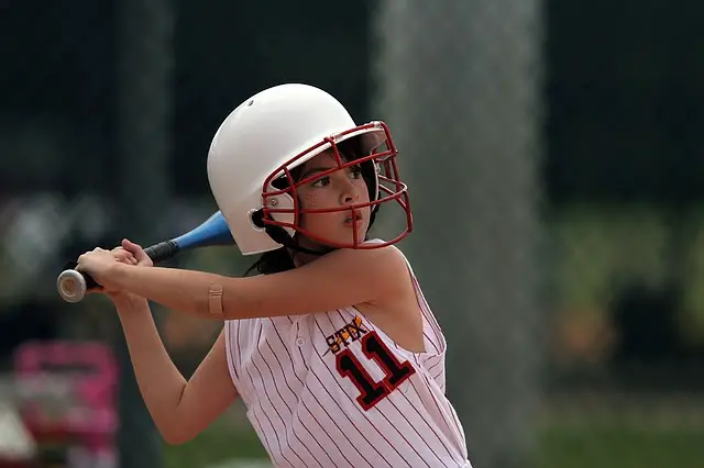 Playing softball with baseball bat